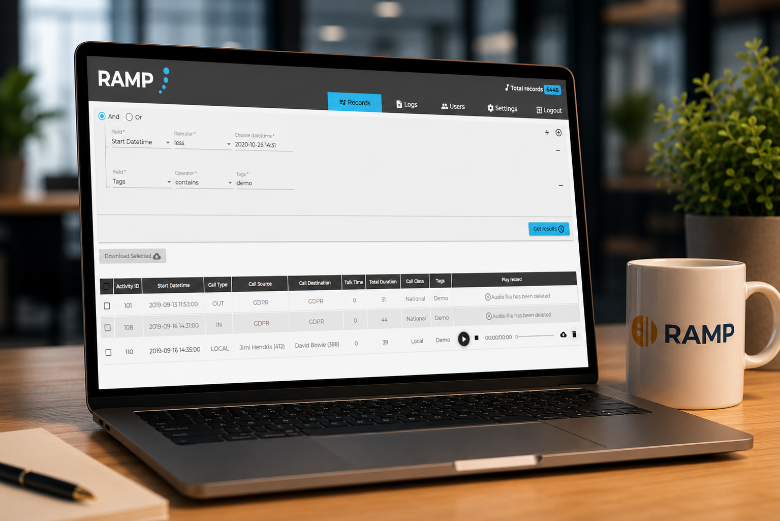 Laptop showing the RAMP call recording archive interface with search filters and a records table, next to a mug displaying the RAMP logo.