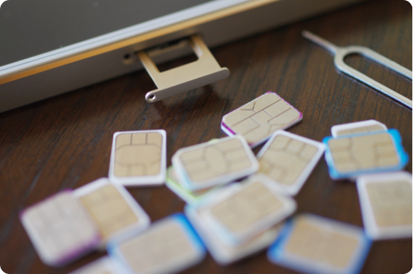 Photograph of several sim cards next to a phone