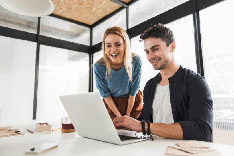 Two people looking at laptop in an office