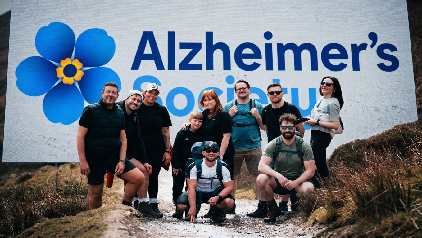 Training for 3 Mountain, Three Peaks Challenge. A team of hikers posing together during a charity mountain climb fundraiser to support the Alzheimer's Society dementia charity.