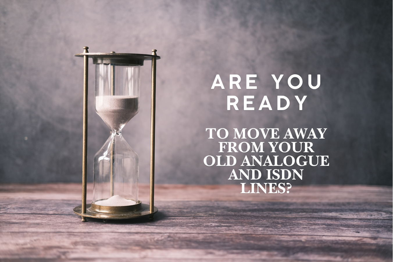 A vintage-style hourglass with white sand running low sits on a rustic wooden table against a grey background. Text to the right reads "Are you ready? For the ISDN switch off?"