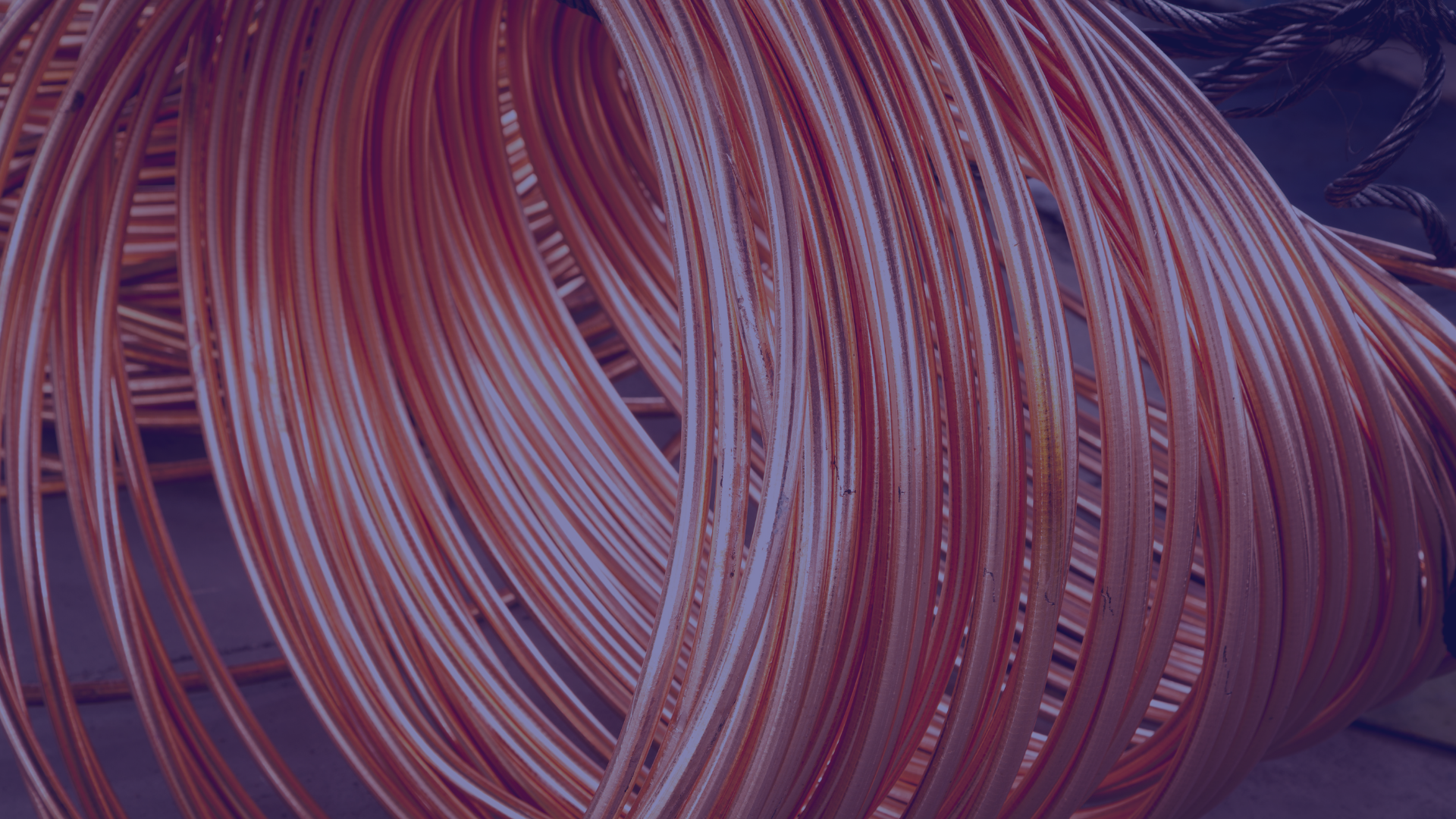 A close-up photograph of a large, coiled bundle of bright copper wiring. The image has a warm, orange-toned overlay, highlighting the texture and metallic sheen of the traditional legacy telecommunications cables.