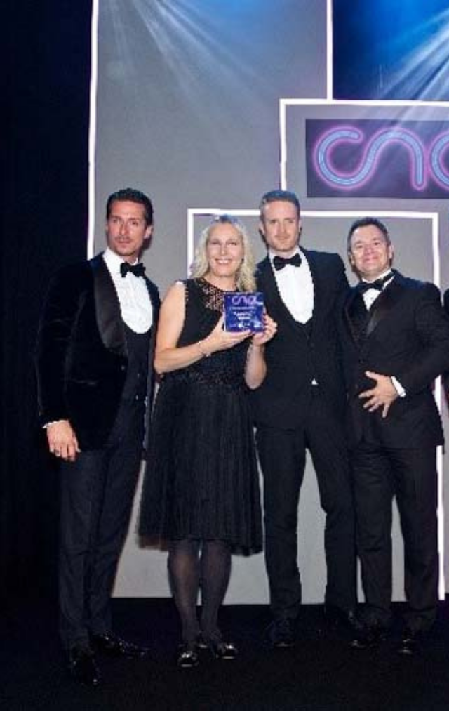 CNA Awards photo with 3 men and a women on stage accepting the award