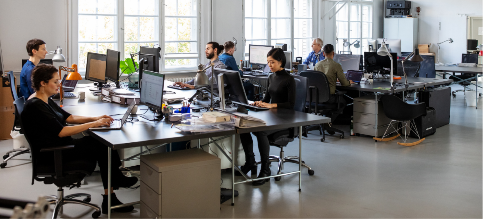 Busy office, several men and women sat at desks