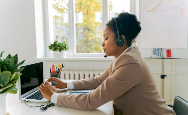 A female call centre employee at a desk speaking into a telephone headset