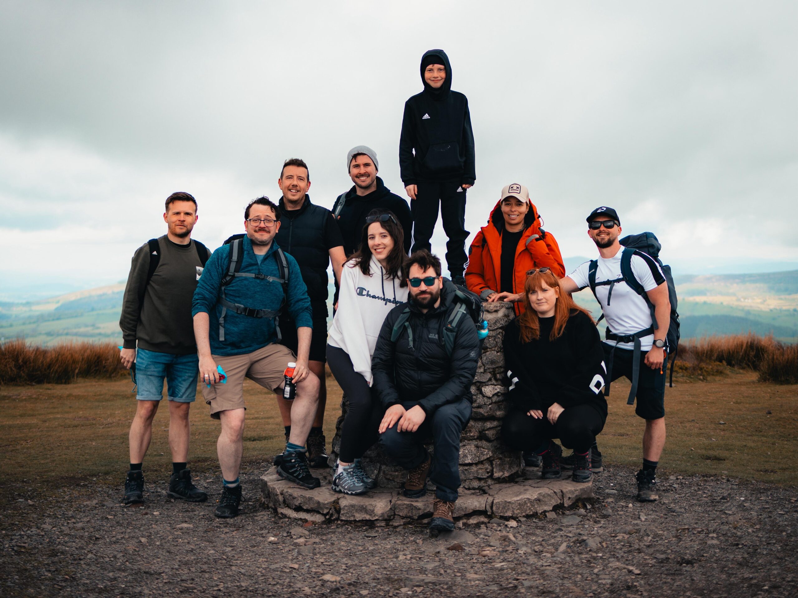 Fundraisers celebrating at a mountain summit during a training walk for the National Three Peaks dementia charity challenge.
