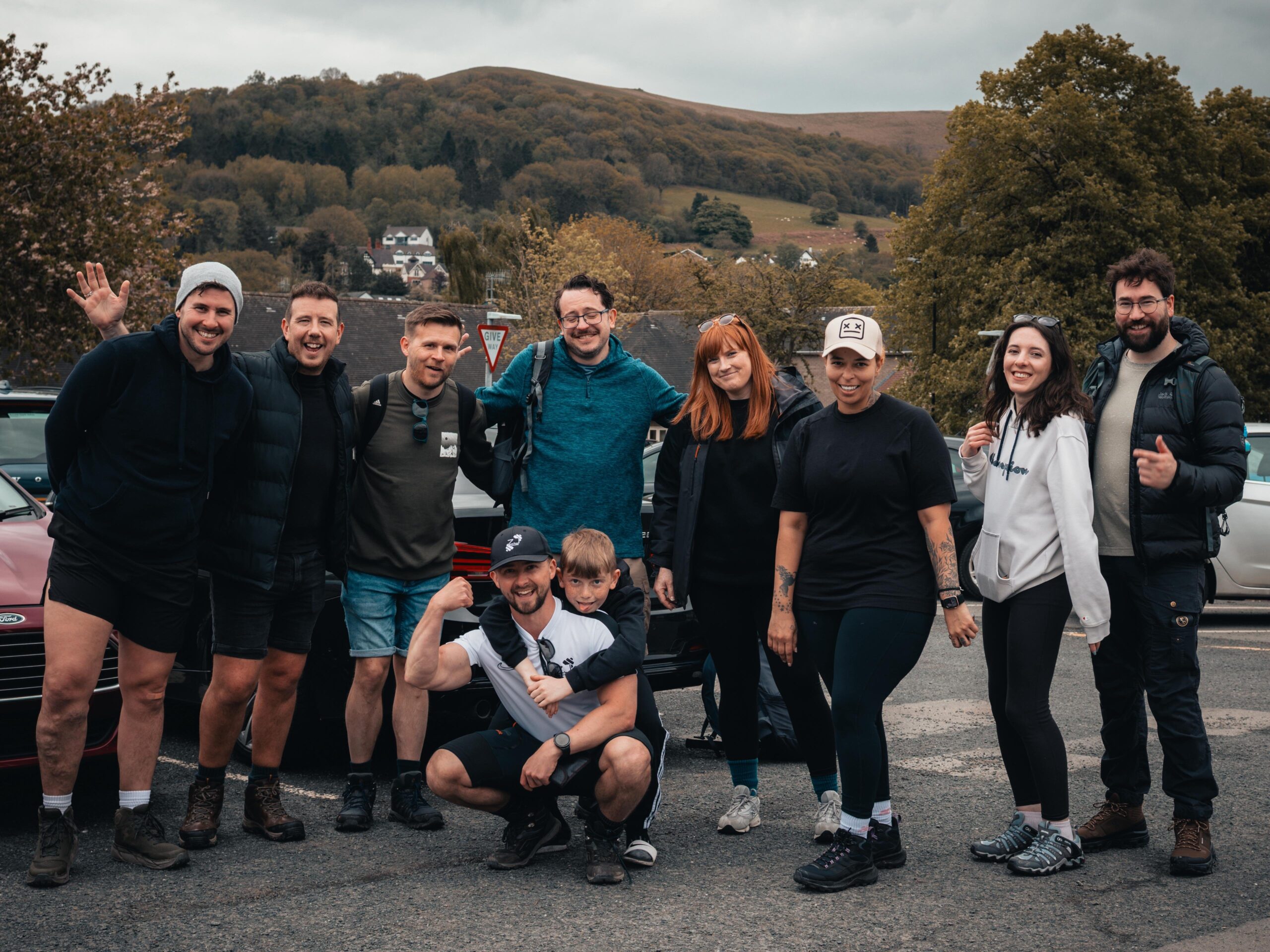 A team of fundraisers smiling together before a training walk for the Three Peaks challenge supporting an Alzheimer's dementia charity.